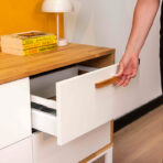 biała komoda na metalowych nogach z szufladami