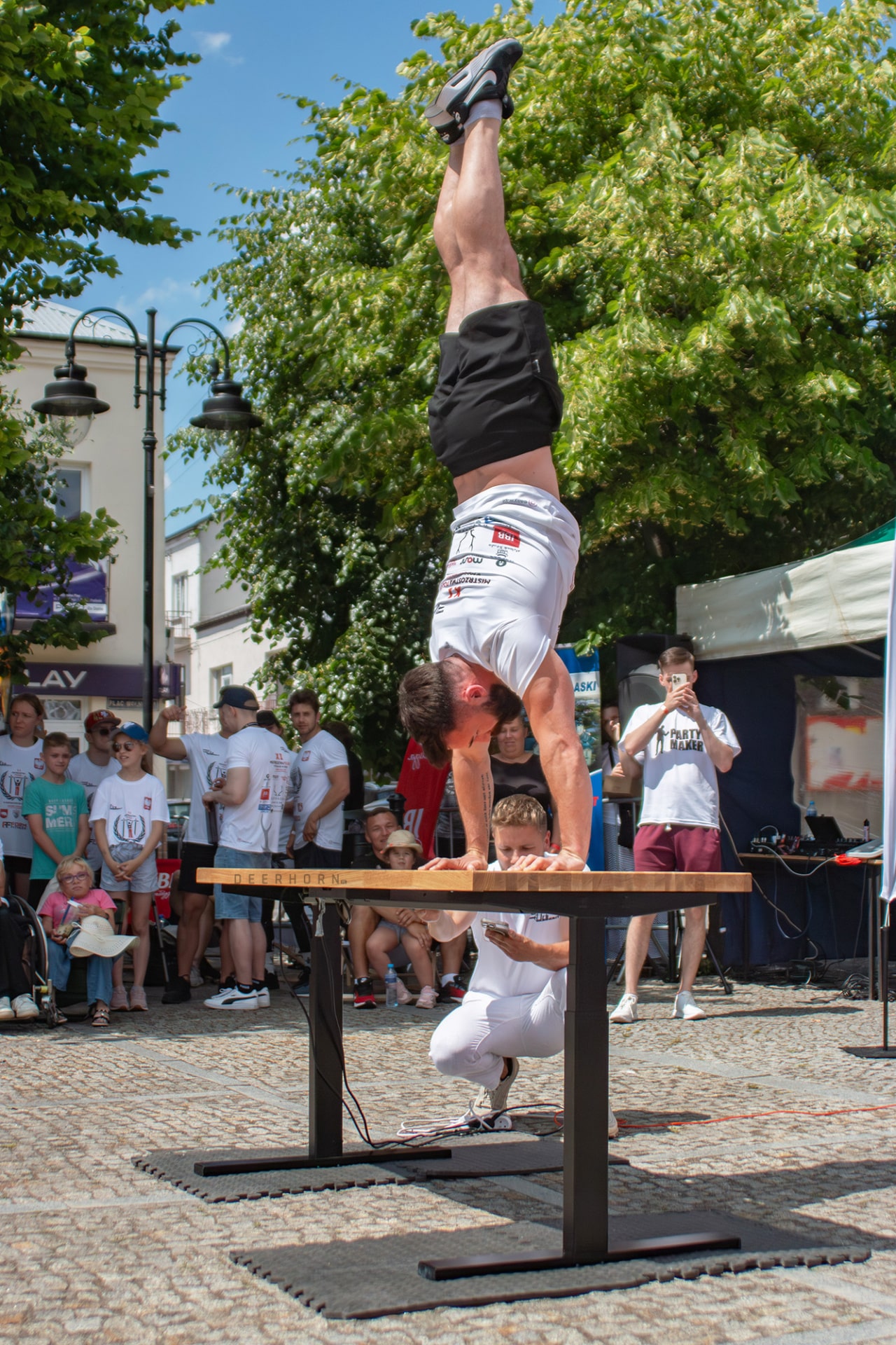 Spieler auf Händen stehend, auf einem regulierten Schreibtisch