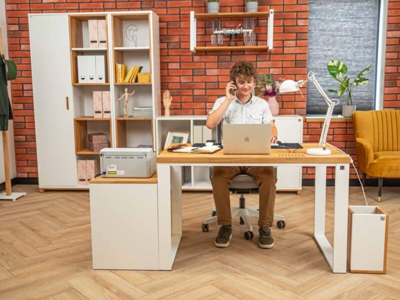 weißer Schreibtisch, an dem ein Junge sitzt und arbeitet