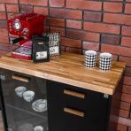 schwarzer Schrank unter Kaffeemaschine mit Tassen und Kaffee