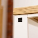 Schreibtisch mit weißem Gestell und Holzplatte