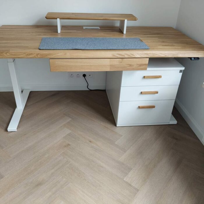 Verstellbarer Schreibtisch mit Holzplatte und weißem Sockel mit drei Schubladen
