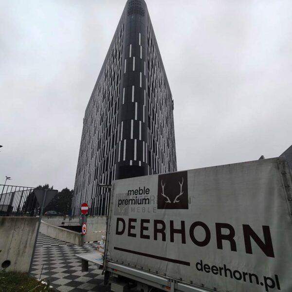 Auto mit großem Deerhorn-Logo, im Hintergrund der moderne DL Tower-Wolkenkratzer in Kattowitz, Polen