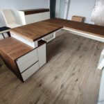Eckschreibtisch in dunklem Holzton mit weißen Akzenten in einem modernen Interieur
