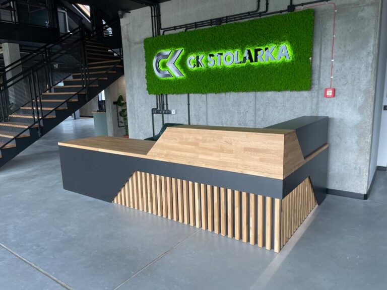 Moderner Empfangstresen mit Holzplatte und geometrischer Front in einem industriellen Interieur