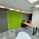 Moderner Büro-Eckschreibtisch vor einer grünen Mooswand für die Fahrschule ZERO in Friedrichshafen (Deutschland)