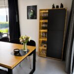 Ein Esstisch mit Eichenholzplatte und eine Vitrine mit LED-Beleuchtung
